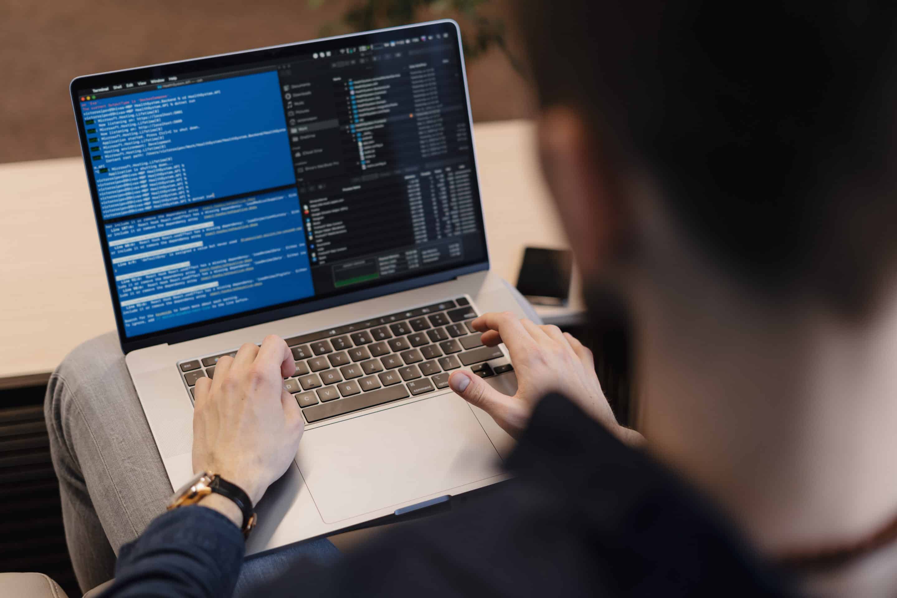 close up man writing code laptop scaled