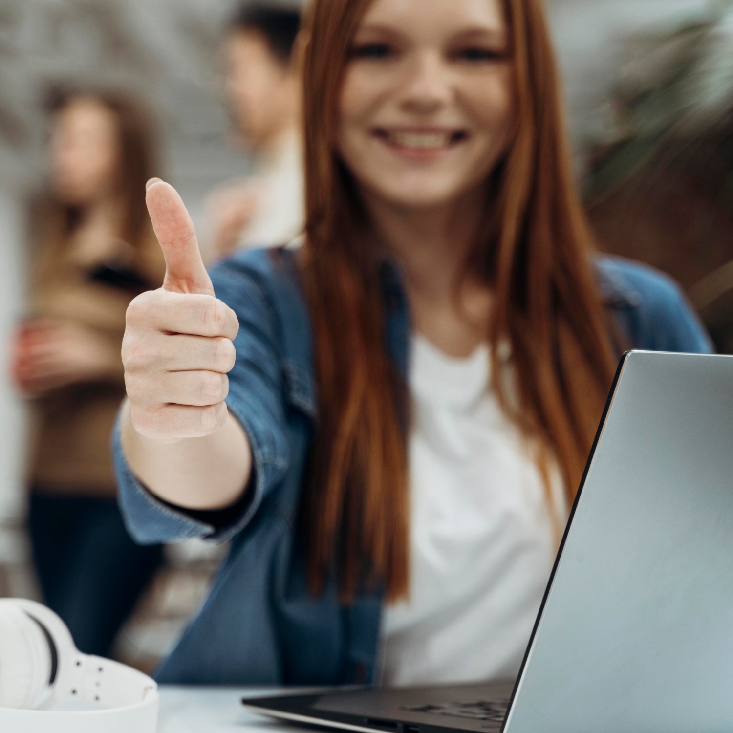 smiley redhead business woman giving thumbs up